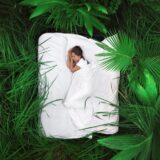 緑のジャングルの中のベッドで眠る女性